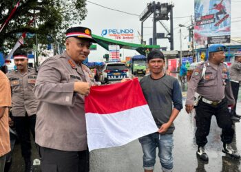 Polresta Ambon Bagikan 200 Bendera Merah Putih di Tengah Hujan Sambut HUT ke-80 RI